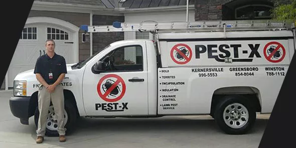 Pest technician standing in front of truck